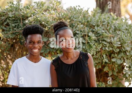 Schwarz Mutter rollt Augen bei lachen preteen Sohn in weiß t-Shirt Stockfoto