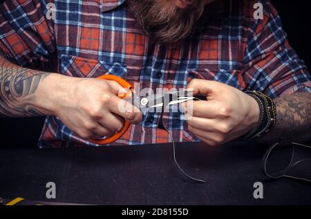 Handwerker konzentriert sich auf seine Arbeit im Ledergeschäft. Stockfoto