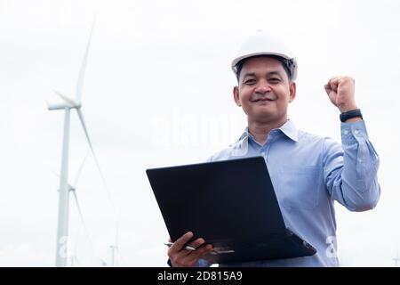 Ingenieure Windmühlen arbeiten an Laptop mit der Windturbine Im Hintergrund Stockfoto