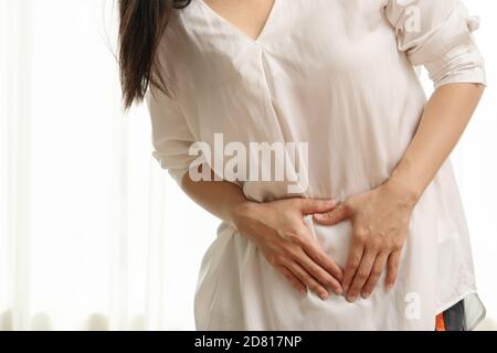 Junge Frau mit Bauchschmerzen Gefühl stomachache, Symptom der pms auf weißem Hintergrund Stockfoto