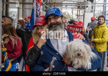 Ein Präsident Trump Anhänger mit einem Haustier gesehen, wie die Teilnehmer vor Trump Tower während des Protests versammeln.Pro-Präsident Trump Anhänger marschieren entlang der 5. Avenue mit Karawane von Autos und riesigen Trump blau, weiß, schwarz Flagge. Sie marschieren vom Trump Tower auf der 5th Avenue zur 42nd Street und von dort zum Times Square, wo sie sich mit Gegenprotestierenden trafen. Die Anti-Trump-Demonstranten schleuderten Beleidigungen und Gegenstände wie mit Farbe gefüllte Flaschen und Eier. Es gab viele Handgemenge zwischen diesen beiden Gruppen und die Polizei machte mehr als ein Dutzend Verhaftungen. Stockfoto