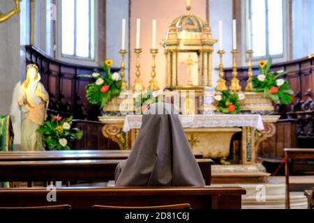 Assisi - August 2019: Innenraum der San Rufino Kathedrale und eine Nonne beten Stockfoto