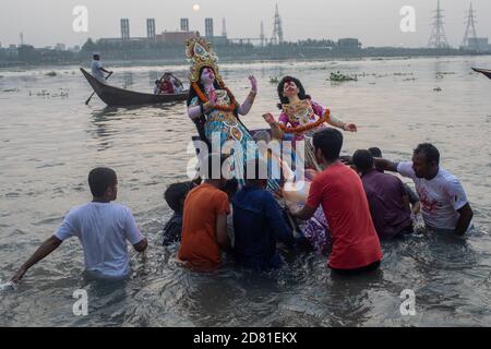 Hinduistische Anhänger tauchen das Idol der Hindu-Göttin Durga auf dem Buriganga Fluss ein am letzten Tag des Durga Puja Festivals wird das viertägige Durga Festival in ganz Bangladesch gefeiert und gipfelt im Eintauchen der Idole der Hindu-Göttin Durga, um Macht und den Triumph zu symbolisieren Gut über Böse in der hinduistischen Mythologie. Stockfoto