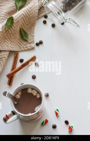 Weihnachtsbecher mit heißer Schokolade mit Zimtstangen, Schokoladenstückchen und Marshmallows Stockfoto