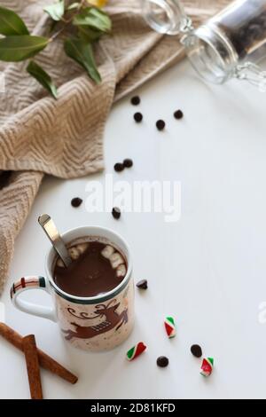 Weihnachtsbecher mit heißer Schokolade mit Zimtstangen, Schokoladenstückchen und Marshmallows Stockfoto
