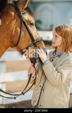 Bindung zwischen Tier und Mensch. Ingwer Mädchen Blick auf ihr Pferd mit dem Vertrauen. Stockfoto