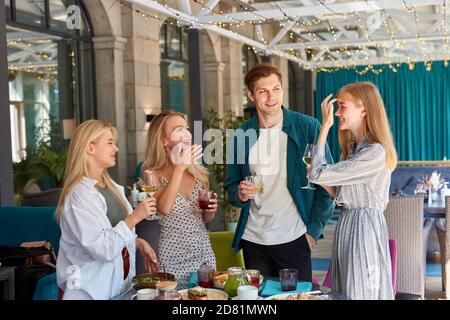 Gruppe von besten Freunden, die eine tolle Zeit im Restaurant, Geburtstag oder Corporate feiern, sie plaudern und trinken Weißwein Stockfoto