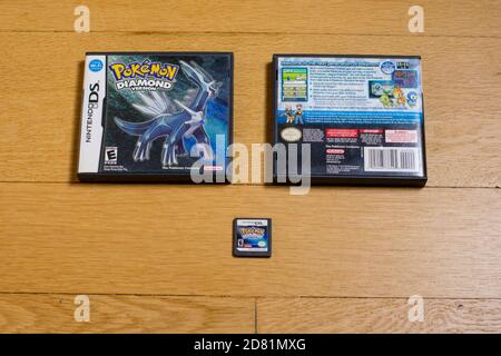 Eine Pokemon Diamond Cartridge und die Vorder- und Rückseite von IT's Game Case für den Nintendo DS auf einem Holzboden. Stockfoto