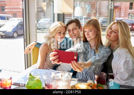 Überglücklich kaukasische Menschen posieren für Foto im Café zusammen, Selfie auf dem Smartphone nehmen, posieren für Foto im Café zusammen, Aufnahme Video für soziale Netzwerk, Spaß mit Freunden Stockfoto