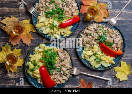 Geröstete Steinpilze und gebratene Kartoffeln auf dem Teller, Nahaufnahme, Draufsicht. Ukraine Stockfoto