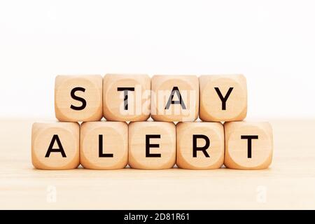 Bleiben Sie wachsam Konzept. Holzblöcke mit Text auf Tisch. Speicherplatz kopieren Stockfoto