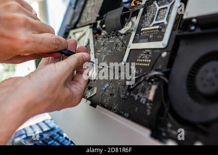 Selektive Fokus der Ingenieur Hände Reparatur Silber Desktop-Computer während Öffnen der Schraube mit einem Schraubendreher zur Analyse von Problem und Beheben Sie es Stockfoto