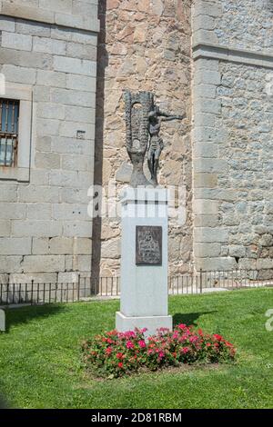 AVILA, SPANIEN - 2020. August 14: Selektives Fokusbild einer Statue eines Kruzifixes und der Wände von Avila Spanien und einem Zeichen, das ' Symbol von Avila ' liest Stockfoto