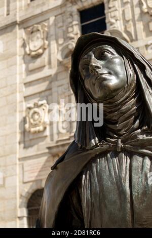 AVILA, SPANIEN - 2020. August 14: Selektives Fokusbild der Bronzestatue der heiligen Teresa von Jesus vor der Kirche, die ihren Namen auf einer Sonne trägt Stockfoto