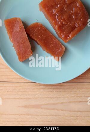 Ansicht von oben nach unten der hausgemachten Quince Paste: Dulce de Membrillo. Geschnitten auf einem grünen Teller auf einem Holztisch, mit Copyspace unten. Ein süßer Leckerbissen, der ein ist Stockfoto