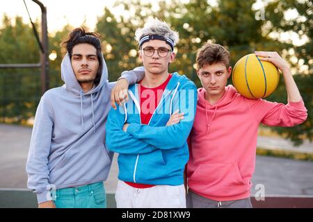 Freundliche Gruppe von kaukasischen Jugendlichen Jungen bereit, Basketball zu spielen, sportliche junge Jungs voller Energie und Kraft. Menschen, Jugend, junge Generation Konzept Stockfoto