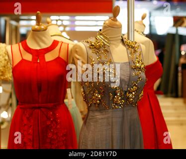 Weibliche Schaufensterpuppen in schönen roten und grauen festlichen Kleidern mit goldenes Dekor in der boutique des indischen Bekleidungsladens Stockfoto