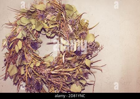 Dekorativer Kranz aus getrockneten Blumen an der Wand Stockfoto