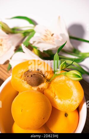 Zusammensetzung von frischen Aprikosen für kulinarische Dessertklasse oder Tapete. Sommerliche Obsternte. Gesunde vegane Ernährung. Rohrezept Stockfoto