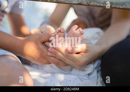 Eltern halten Babyfüße. Im Freien. Nahaufnahme Stockfoto