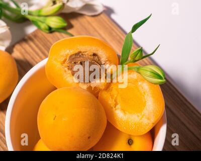 Zusammensetzung von frischen Aprikosen für kulinarische Dessertklasse oder Tapete. Sommerliche Obsternte. Gesunde vegane Ernährung. Rohrezept Stockfoto