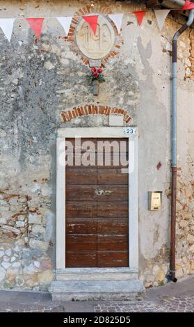 SOAVE, Italien - 25. August 2020: Fassade eines alten kleinen historischen Hauses, mit einem religiösen Flachrelief über der Tür Stockfoto