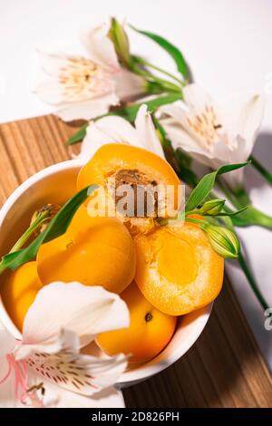 Zusammensetzung von frischen Aprikosen für kulinarische Dessertklasse oder Tapete. Sommerliche Obsternte. Gesunde vegane Ernährung. Rohrezept Stockfoto