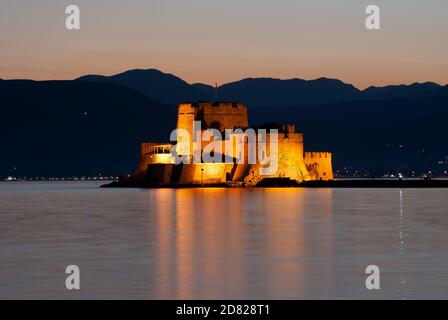 Blick bei Nacht auf Burg von Bourtzi auf der Insel In der Bucht von Nauplia bei Dämmerung Stockfoto