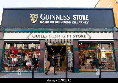 Mann mit Gesichtsmaske vorbei am Guinness Store und Quills Irish Gift Store in High Street Killarney County Kerry Irland Stockfoto