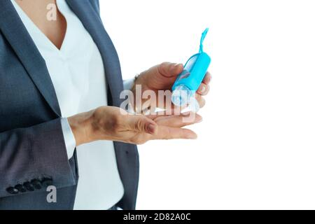 Geschäft während der covid-19 Pandemie. Nahaufnahme einer Geschäftsfrau, die Hände mit Desinfektionsmittel vor weißem Hintergrund desinfiziert. Stockfoto