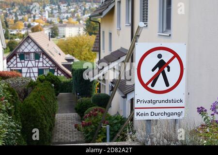 Wohngebiet in einem Schweizer Dorf mit einem Schild, der in deutscher Sprache sagt: Privateigentum, kein Hausfriedensbruch. Die Häuser sind dicht gebaut. Stockfoto