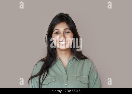 Lächelnd fröhlich junge indische Frau lachend isoliert auf braunem Hintergrund. Stockfoto