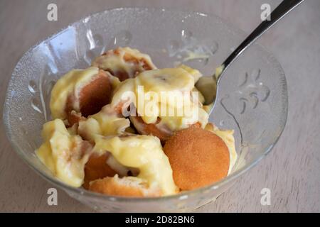 Nahaufnahme einer Portion Bananenpudding mit Pudding, Vanilleplätzchen und in Scheiben geschnittenen Bananen in einer Schüssel mit Löffel serviert. USA. Stockfoto