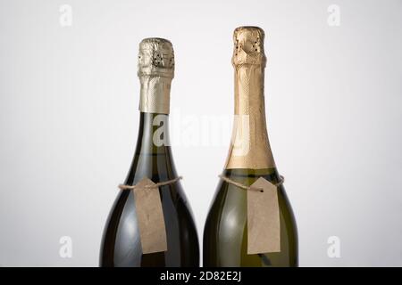 Champagnerflaschen mit Handetiketten auf hellem Hintergrund. Stockfoto