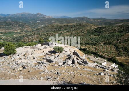 Blick auf die Ruinen der archäologischen Stätte Mykene im Hintergrund auf die griechische Landschaft mit Olivenbäumen, Griechenland Stockfoto