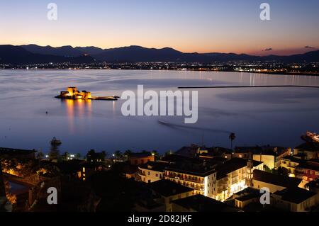 Luftaufnahme bei Nacht der Bucht Nauplia bei Dämmerung mit Das Schloss von Bourtzi auf der kleinen Insel Stockfoto