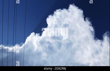 Interessante alternative kreative Ansicht Blick durch Stromleitungen zu weißen flauschigen Wolken Gebäude bis zu einem tropischen Gewitter. Intensiv tief BL Stockfoto