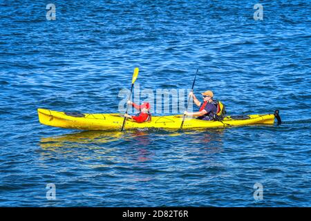 Der Vater lehrt die Kunst des Kajakfahrens, während sein Sohn im Wasser in Elliott Bay praktiziert. Seattle-Washington, USA Stockfoto