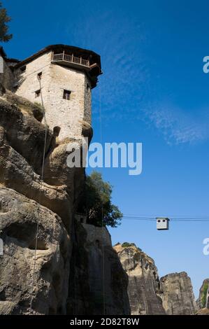 Blick auf einen Klosterturm auf einer Spitze - Meteora in Griechenland - und Seilbahn zu trasport Menschen Und Dinge Stockfoto