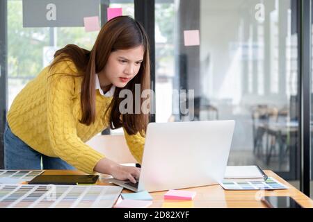 Grafikdesigner, der mit Farbmustern zur Auswahl arbeitet. Grafikdesigner bei der Arbeit. Farbmuster. Junge Fotografin und Grafikdesignerin bei Stockfoto