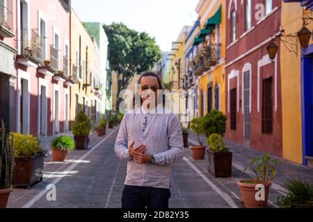 Mexikanischer junger Mann, der auf der farbenfrohen Kolonialstraße von Puebla spazierengeht Stockfoto