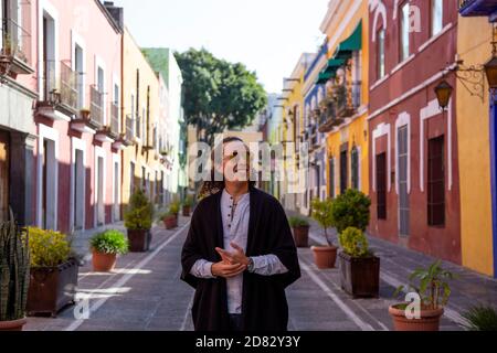 Mexikanischer junger Mann, der auf der farbenfrohen Kolonialstraße von Puebla spazierengeht Stockfoto