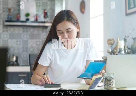 Attraktive junge Asienfrau, die zu Hause arbeitet. Arbeiten und Lernen von zu Hause aus. Stockfoto