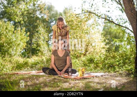 Expert Masseuse bietet eine gründliche Massage in der Natur. Stockfoto