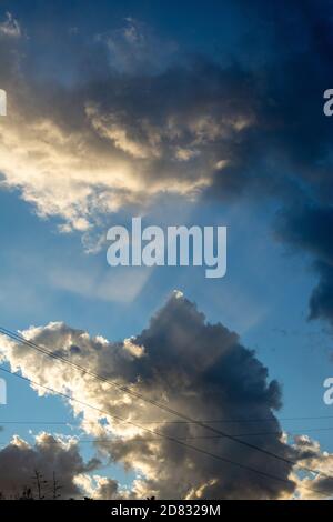 Wetter, Sonne scheint durch Wolken. Sonnenstrahlen, die wie riesige Scherben durch die Wolken strahlen. Stockfoto