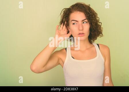 Studio schoss der schönen Jugendmädchen denken, während gegen grün gestrichene Wand hören Stockfoto