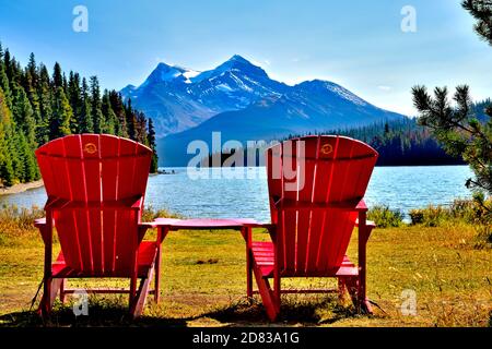 Zwei leere rote Stühle zum Sitzen und bewundern Der Blick auf den Maligne See im Jasper Nationalpark in Alberta Kanada Stockfoto