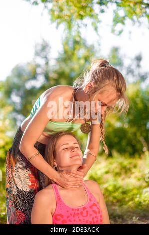 Frau Masseuse bietet eine gründliche Massage in der Natur. Stockfoto