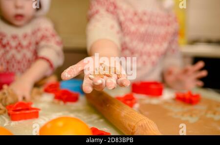 Nahaufnahme der Hände von Kindern, die Cookies ausschneiden. Hausgemachtes Backen Stockfoto