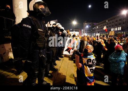 Eine Frau hält ein Schild mit dem Symbol der Frauenstreik-Bewegung vor der Bereitschaftspolizei, die die drei Kreuze-Kirche in Warschau, Polen, am Oktober bewacht Stockfoto